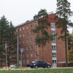 a car is parked in front of a brick building